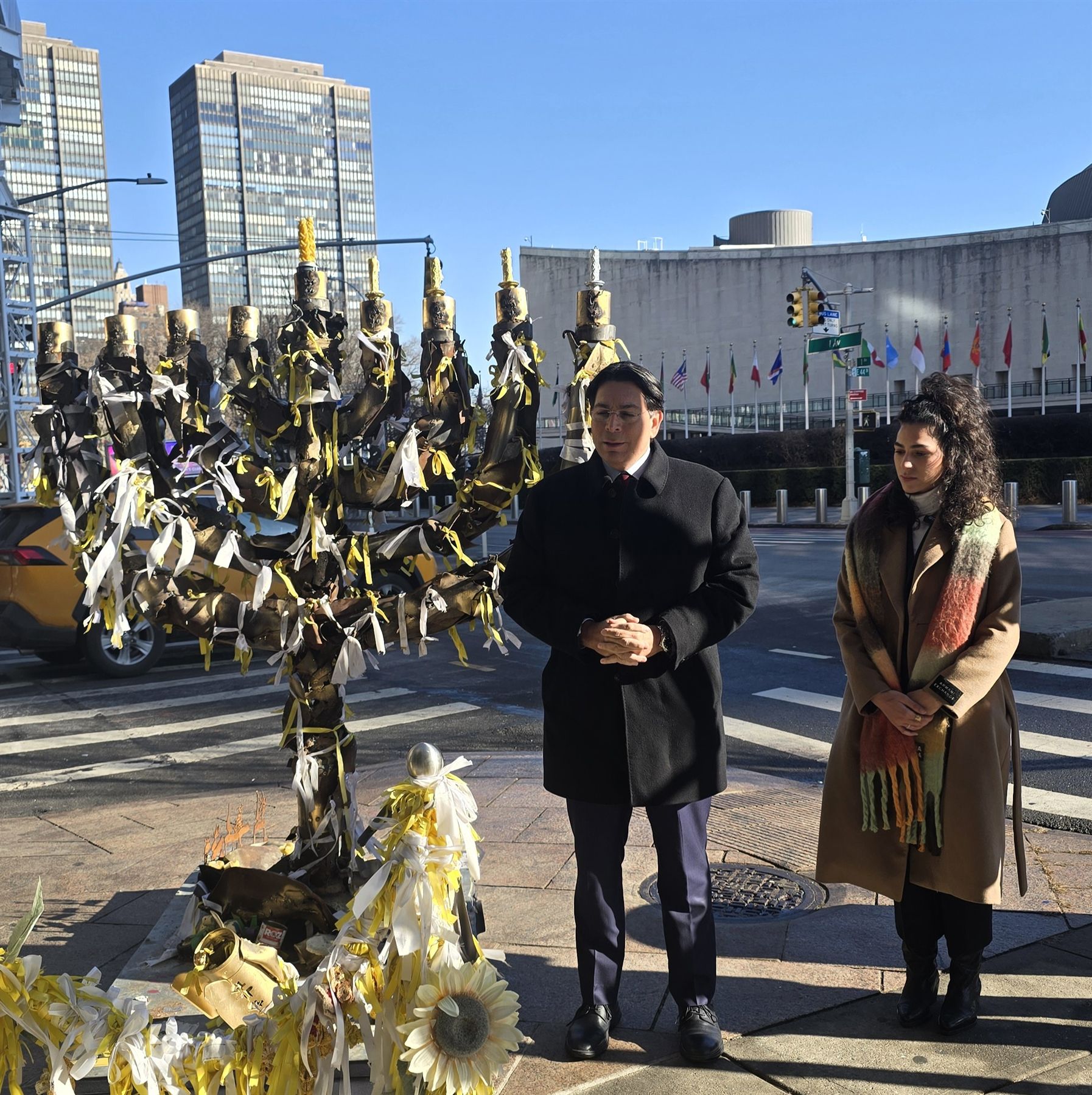 Ambassador Danny Danon and Shira Gvili beside the Menorah of Hope across from the United Nations